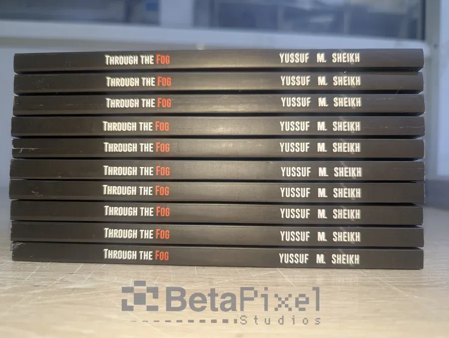 Spines of printed paperback copies lined up, showing the book title and author name
