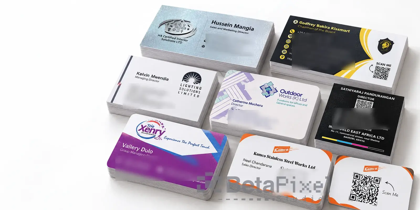 Stacks of printed business cards in different finishes, including metallic, black, rounded-corner and QR code cards (contact details blurred)