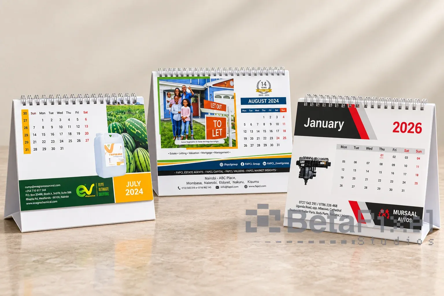 Three spiral-bound desk calendars on tent stands, each with a company photo, monthly grid and contact band