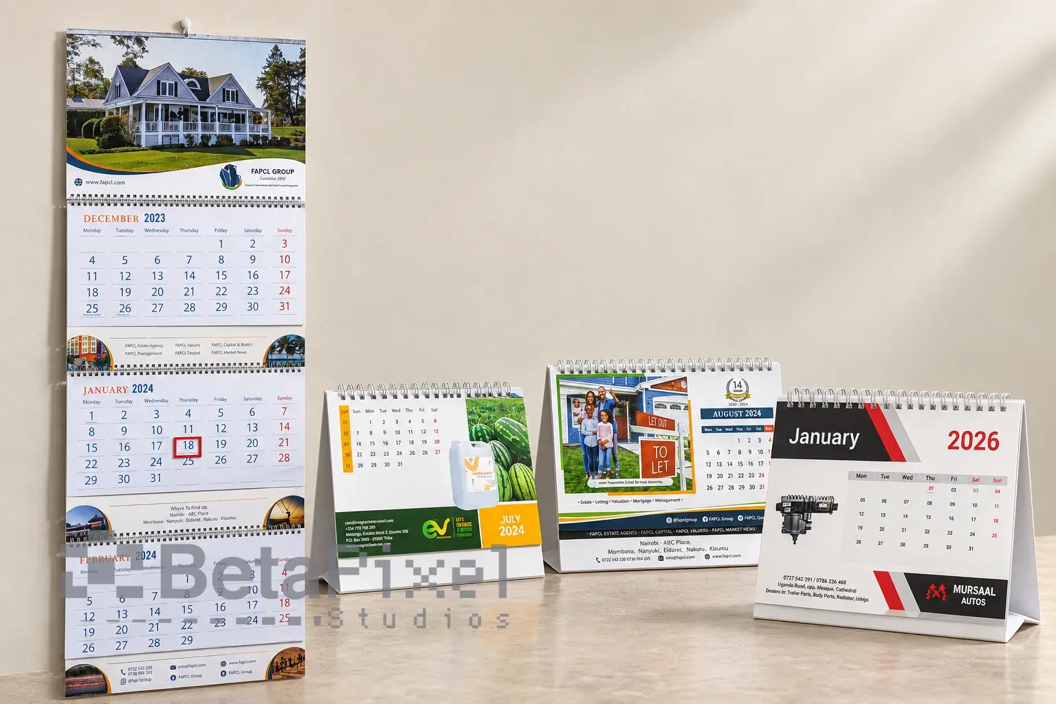Printed three-month wall calendar beside three branded desk calendars for property, agribusiness and auto-parts companies