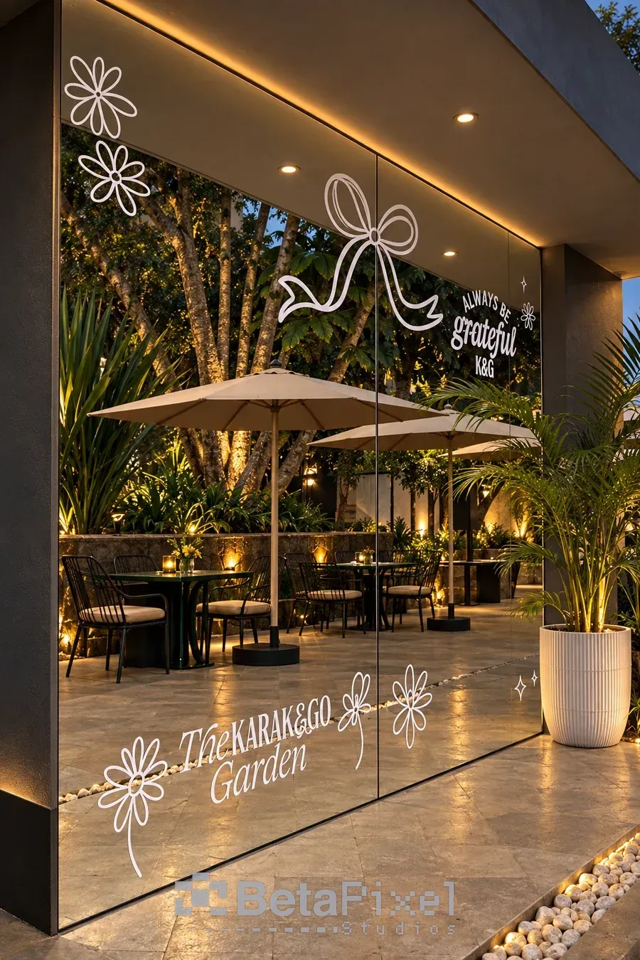 Restaurant glass frontage decorated with white frosted floral designs, a bow and the garden name