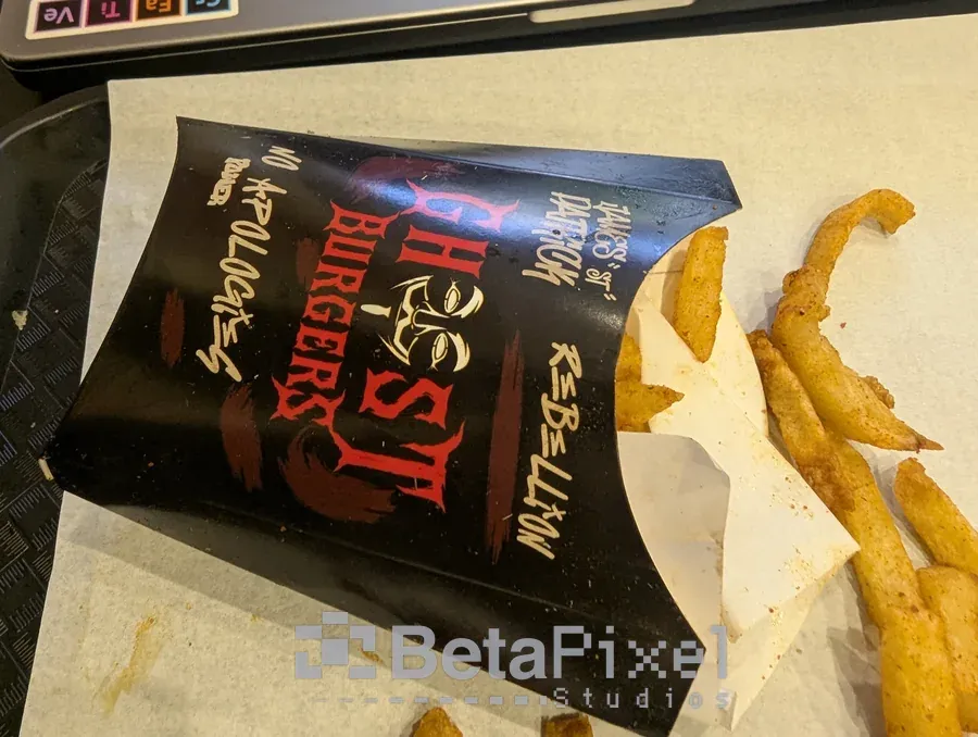 Black printed fries box with red graffiti-style restaurant branding, filled with chips